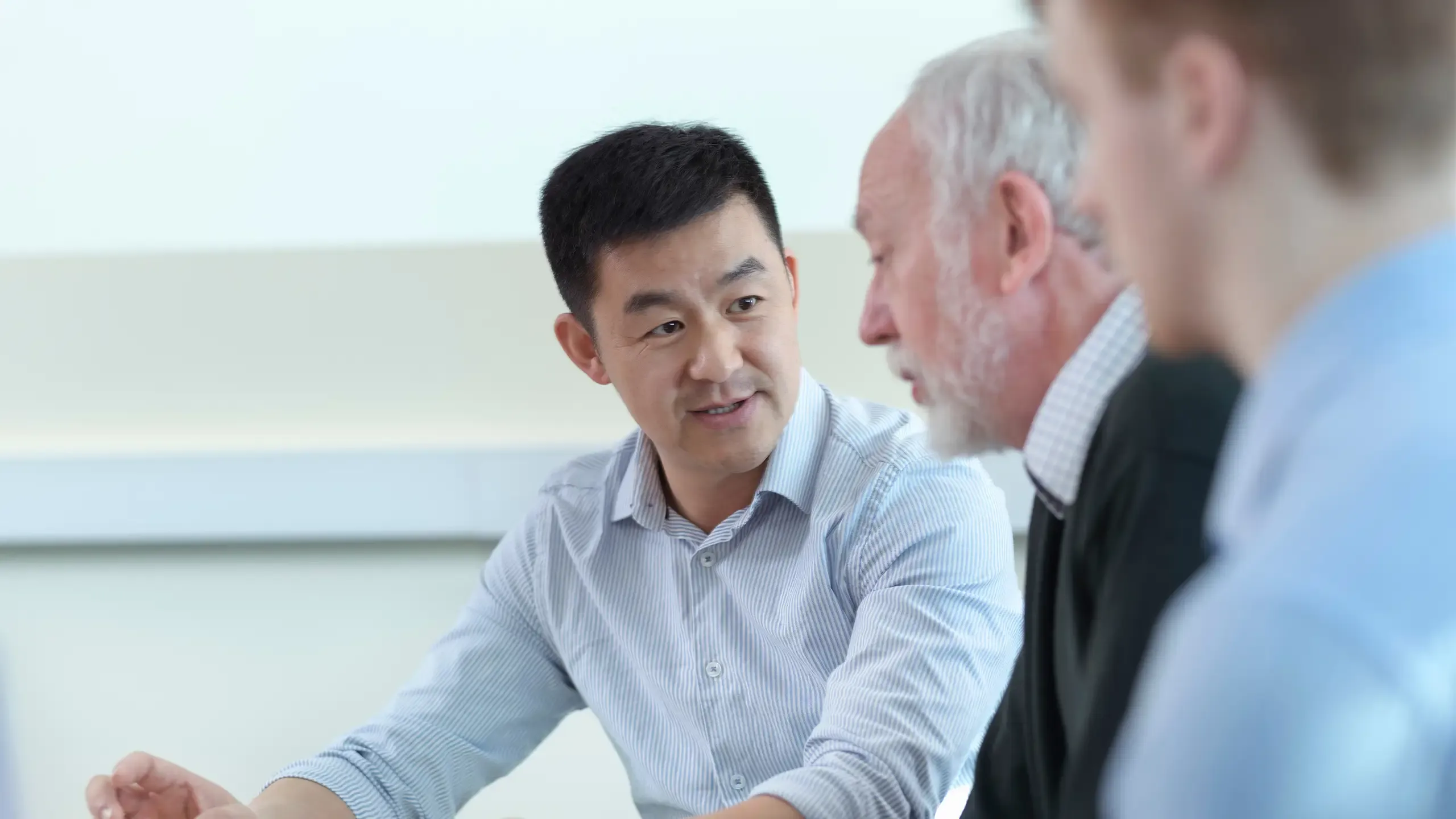 Team colleagues discussing a project in a meeting room. 