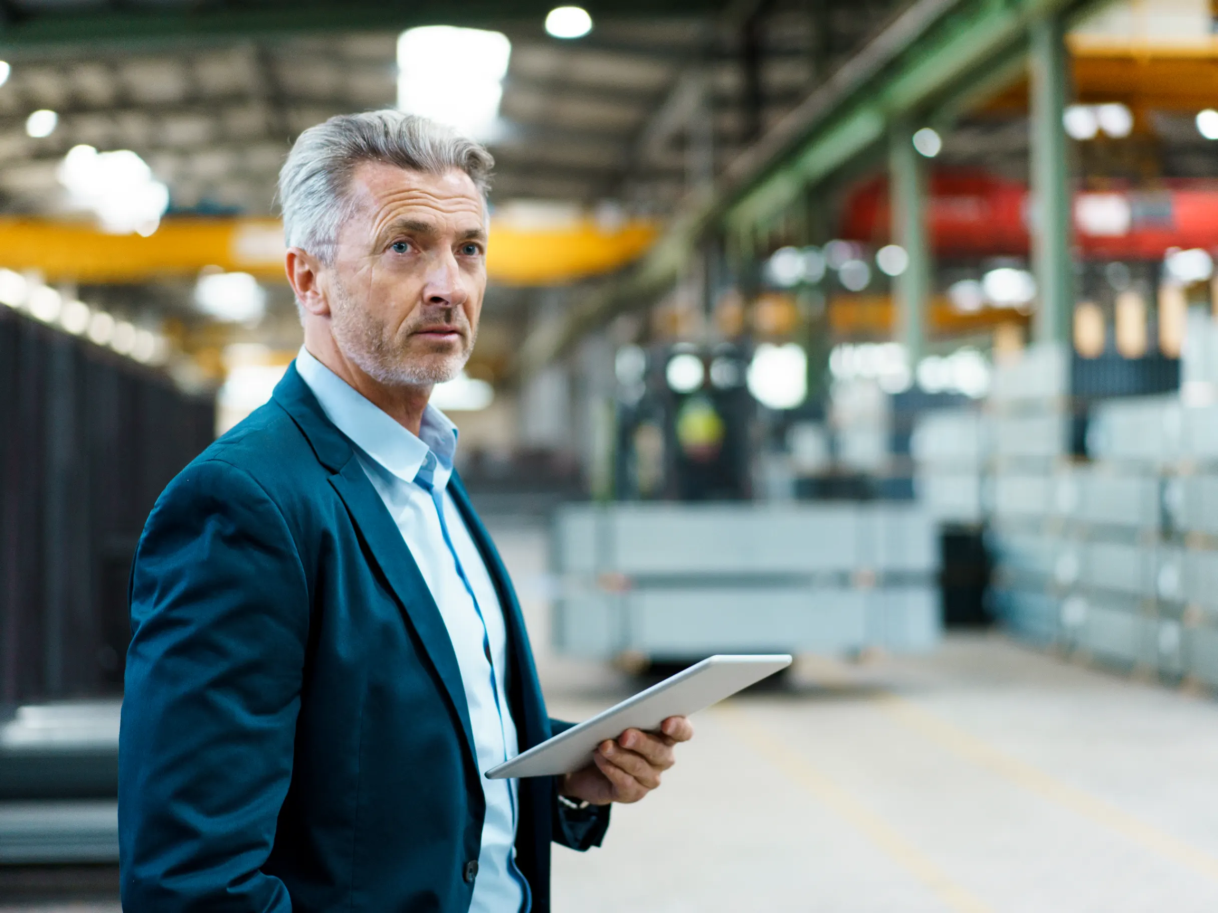Mature businessman holding a tablet in a factory environment