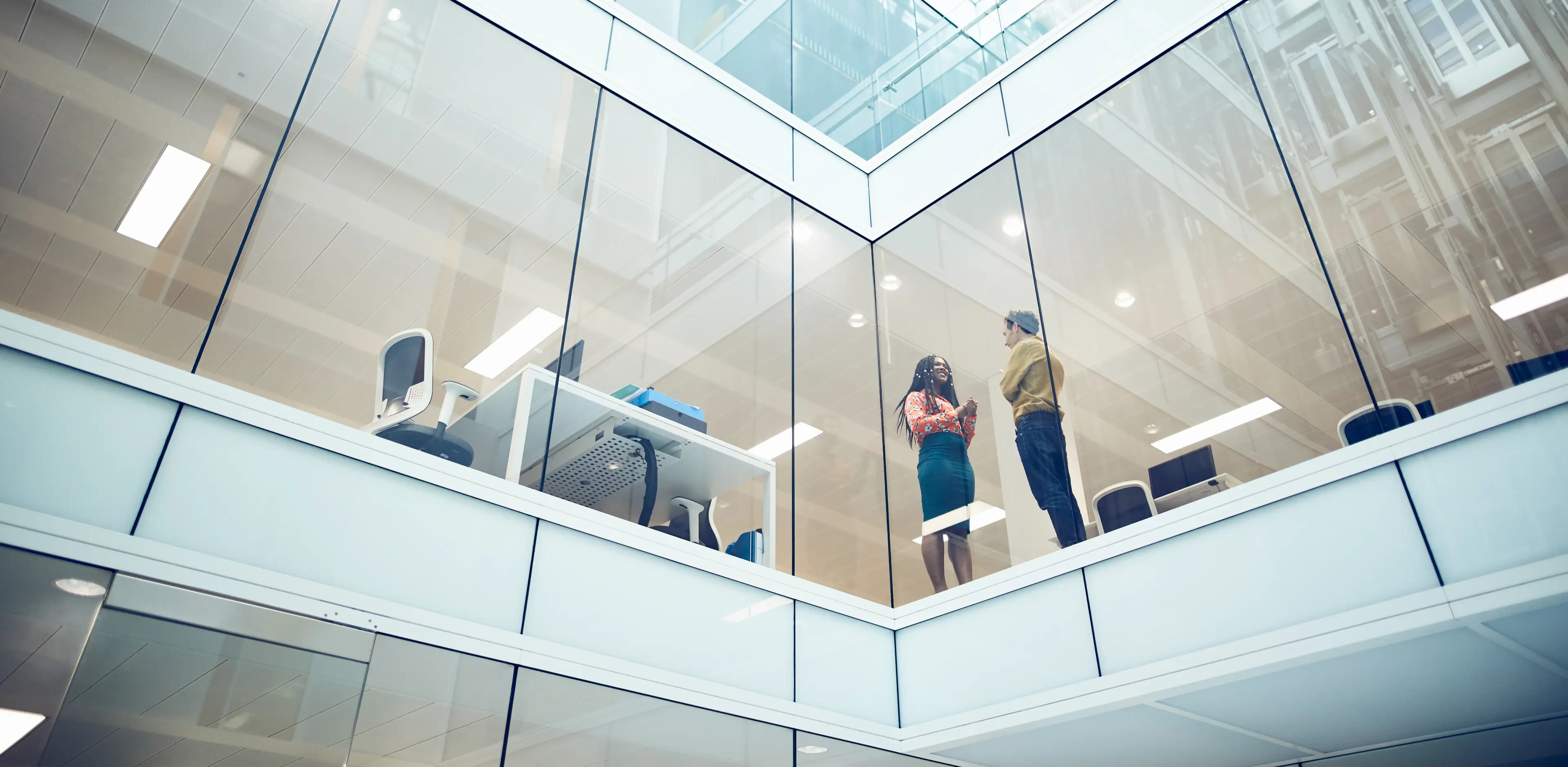 Work colleagues talking in a modern office setting Work colleagues talking in a modern office setting
