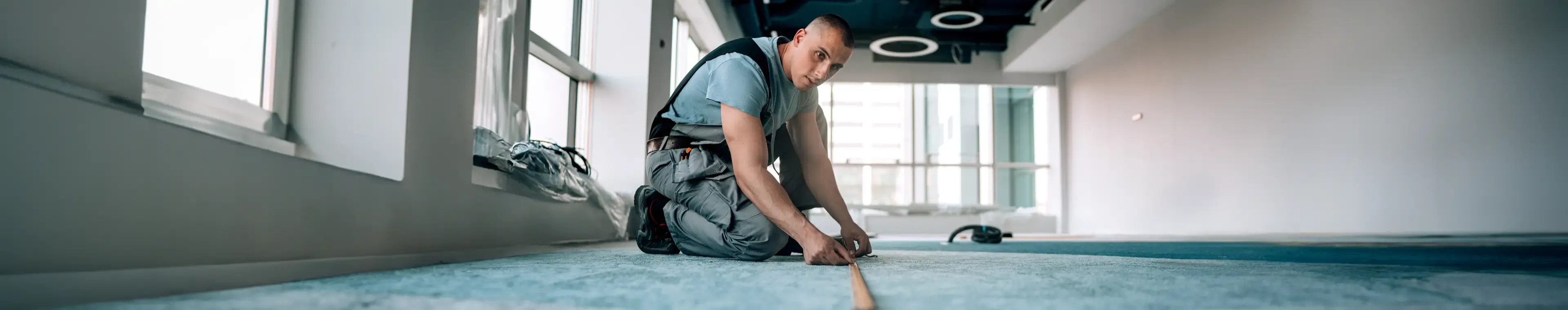 Young man measures the floor for accurate modifications